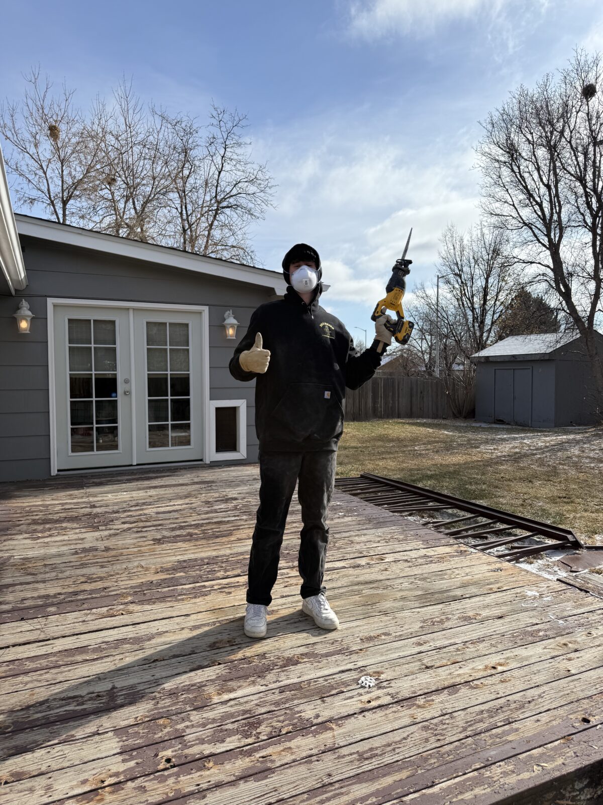 Guy standing on a deck with a power saw